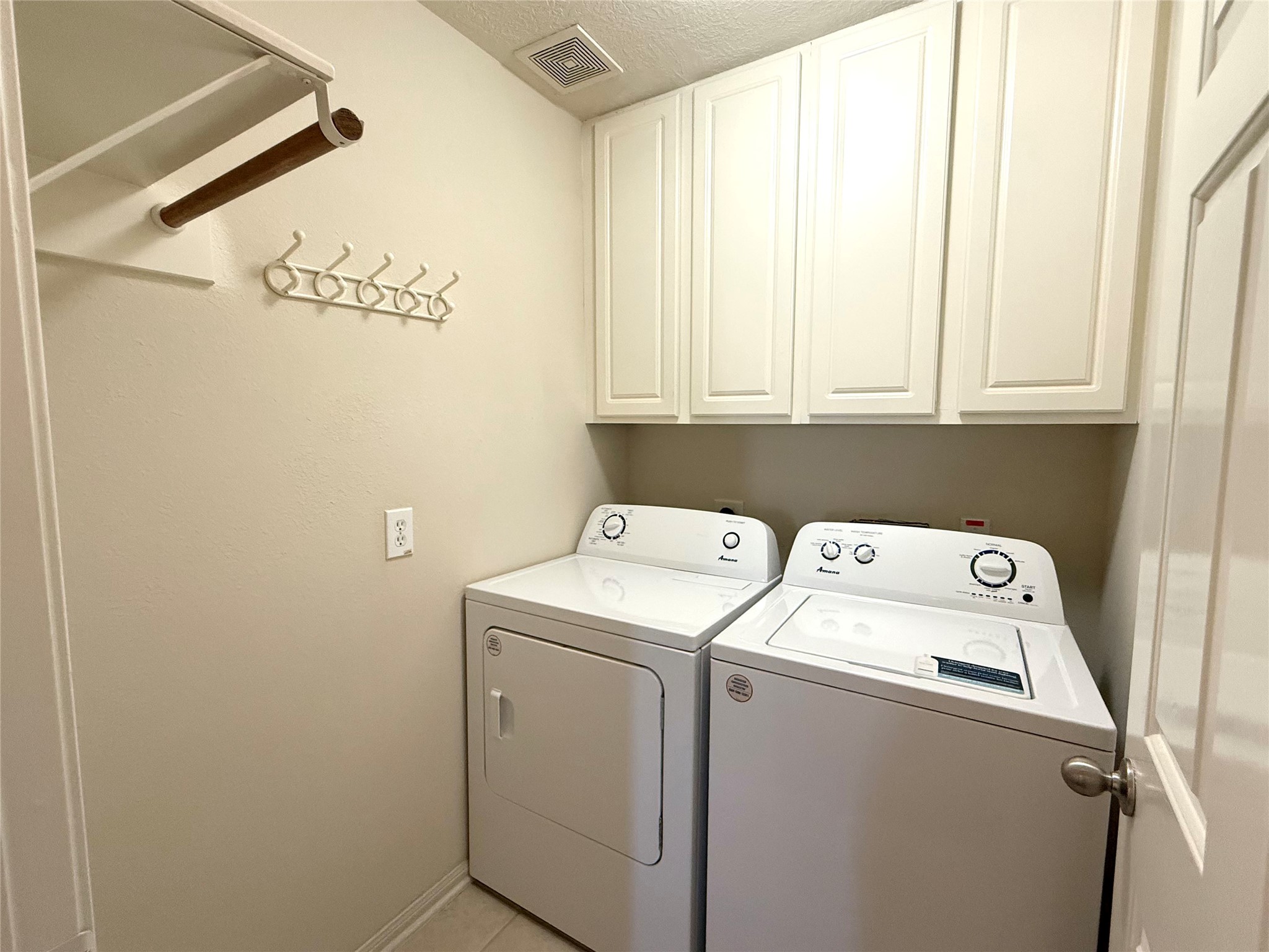 13102 Castlewind Lane Pearland, TX 77584 - Photo 25 of 31 Dedicated laundry room with upper cabinets for storage and convenient hanging rack.