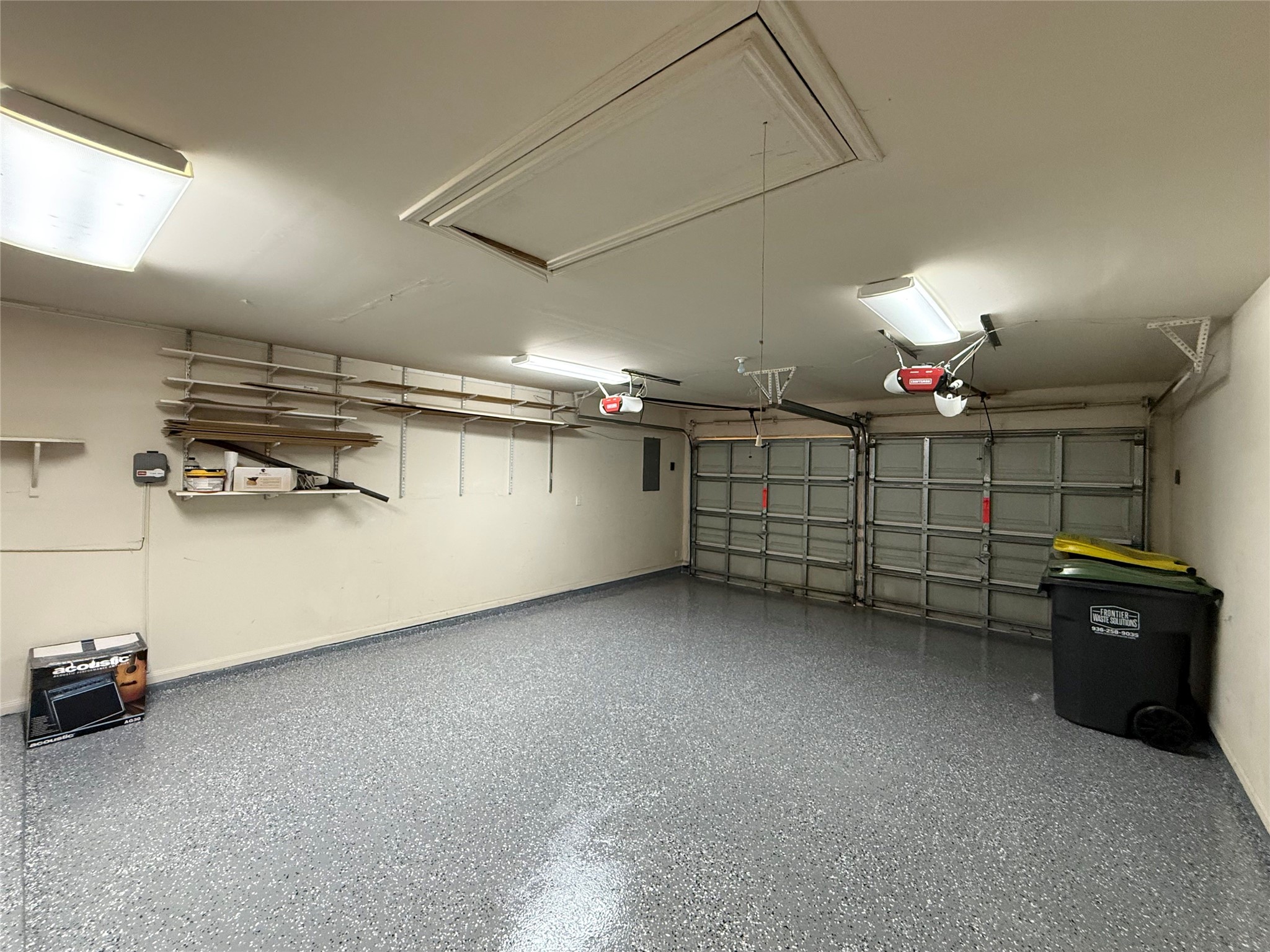 13102 Castlewind Lane Pearland, TX 77584 - Photo 27 of 31 Two-car garage featuring an updated garage floor, bright overhead lighting, and plenty of wall-mounted storage options.