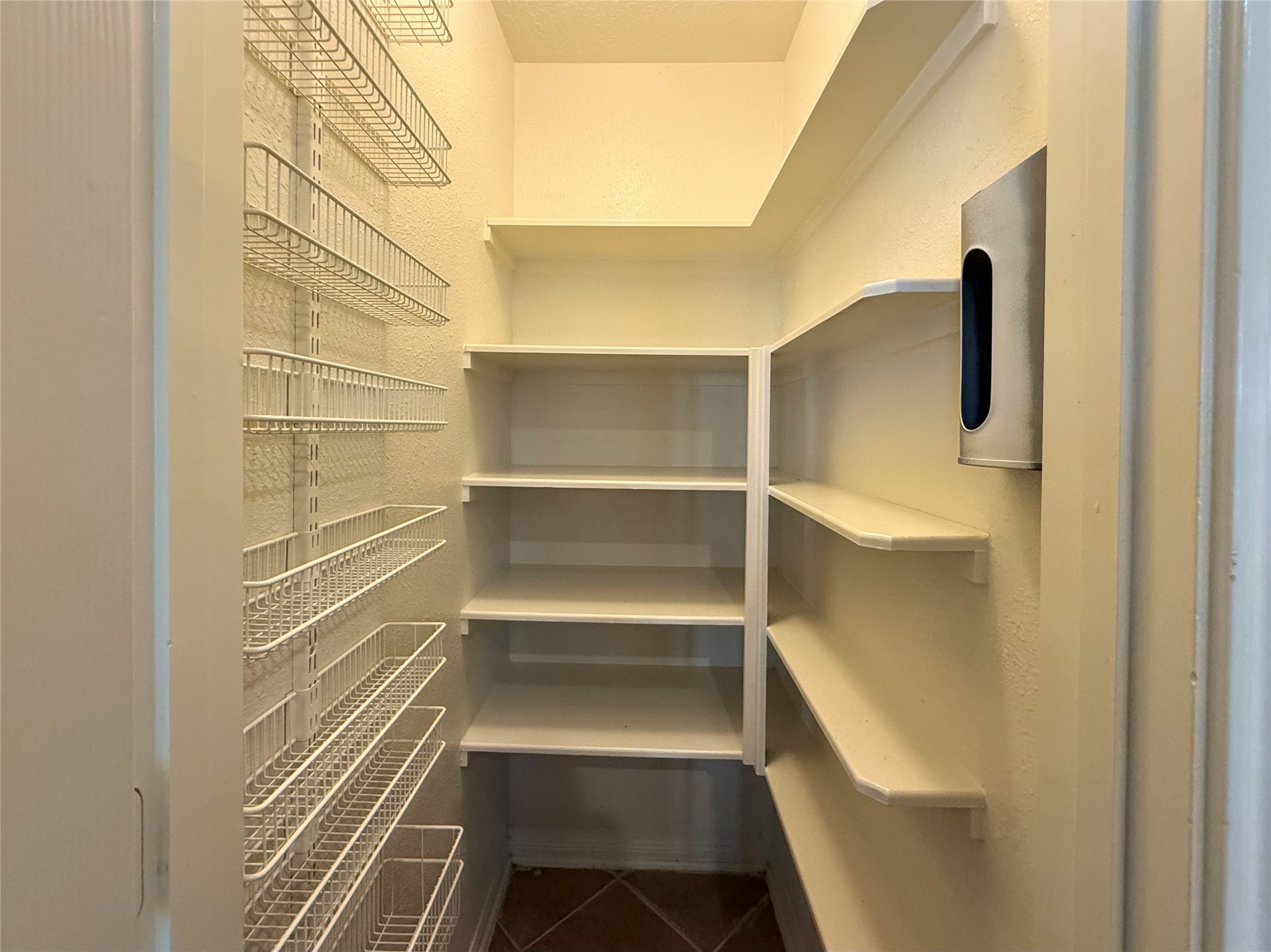 13102 Castlewind Lane Pearland, TX 77584 - Photo 6 of 31 Walk-in pantry with multiple built-in shelves offering ample storage for food, kitchen supplies, and small appliances.