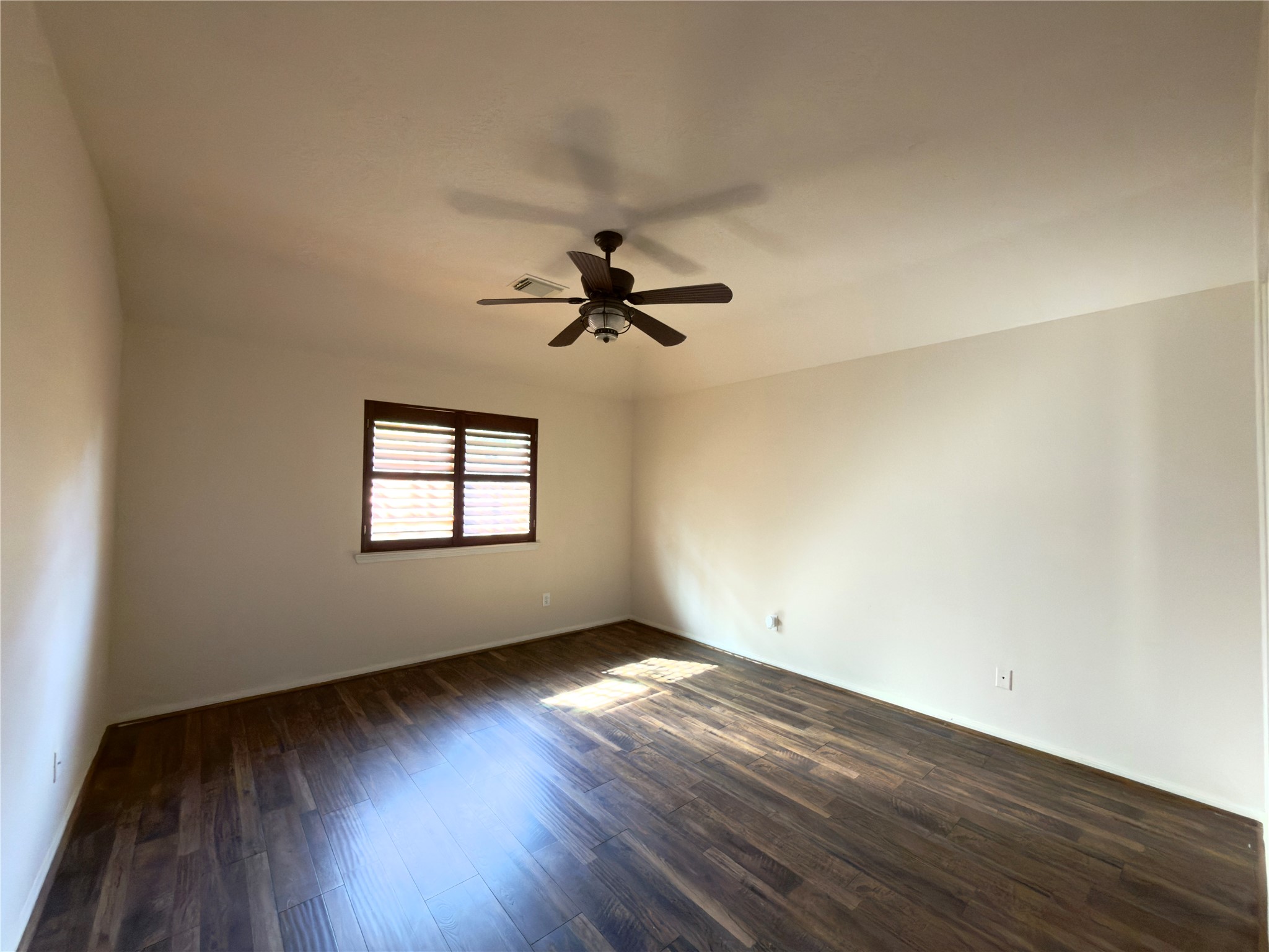 13102 Castlewind Lane Pearland, TX 77584 - Photo 8 of 31 Spacious primary bedroom featuring new flooring, fresh paint, a ceiling fan, and plenty of natural light.