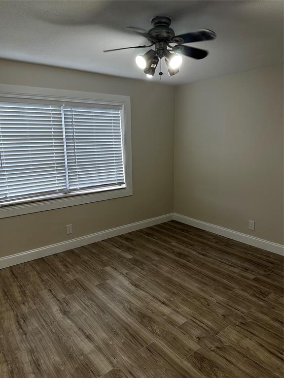 941 Crystal Lake Drive, Unit 201 Deerfield Beach, FL 33064 - Photo 12 of 27 a view of an empty room with wooden floor and a window