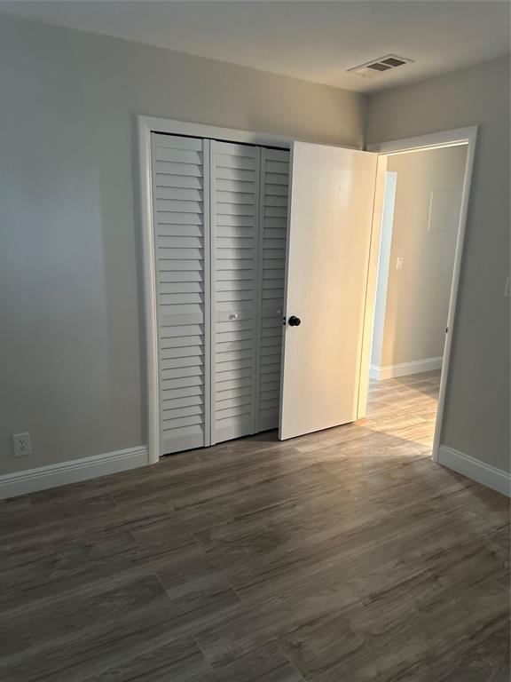 941 Crystal Lake Drive, Unit 201 Deerfield Beach, FL 33064 - Photo 13 of 27 a view of an empty room with wooden floor and a window
