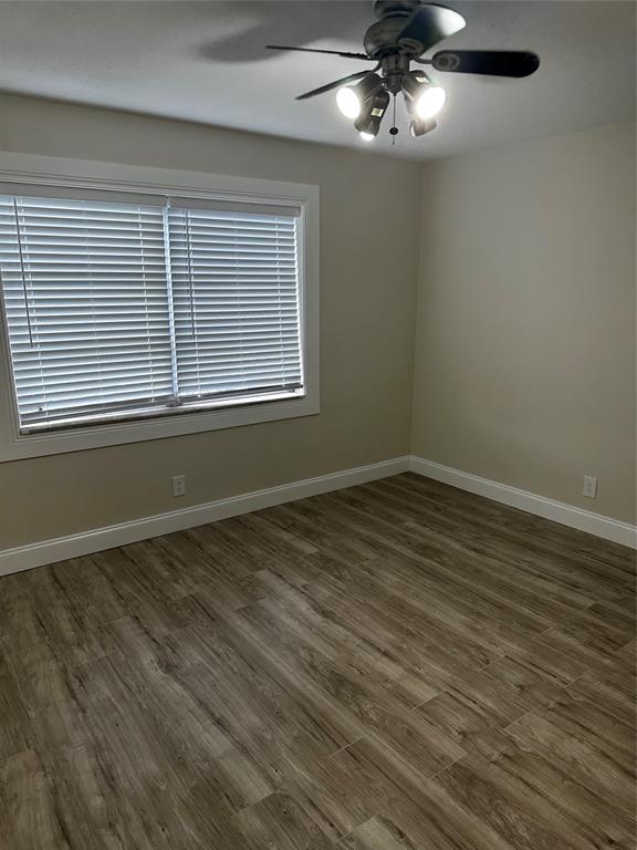 941 Crystal Lake Drive, Unit 201 Deerfield Beach, FL 33064 - Photo 20 of 27 a view of an empty room with wooden floor and a window