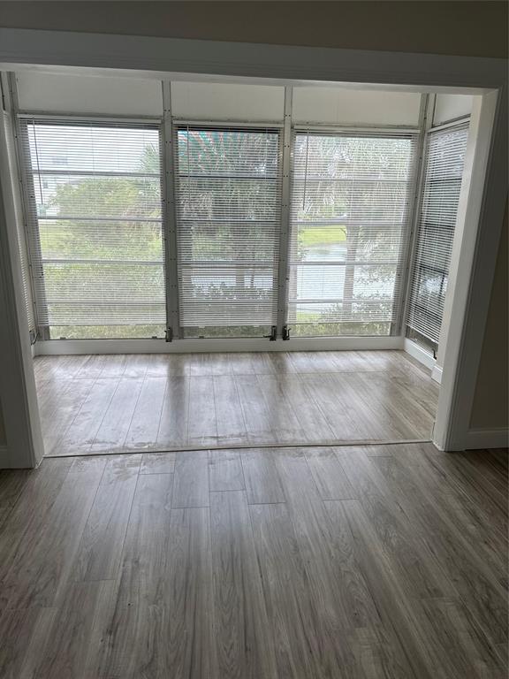 941 Crystal Lake Drive, Unit 201 Deerfield Beach, FL 33064 - Photo 25 of 27 a view of empty room with wooden floor and fan