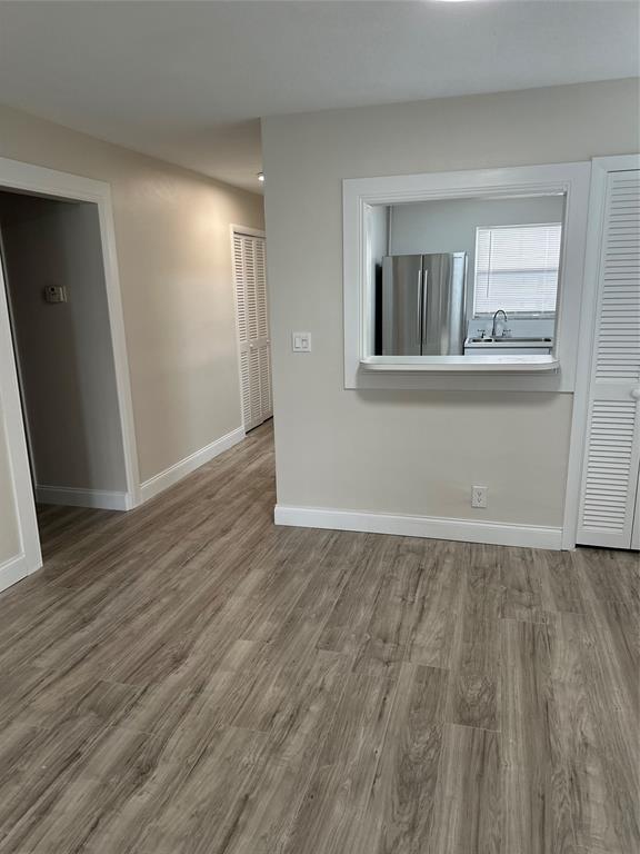 941 Crystal Lake Drive, Unit 201 Deerfield Beach, FL 33064 - Photo 9 of 27 a view of an empty room with wooden floor and a window