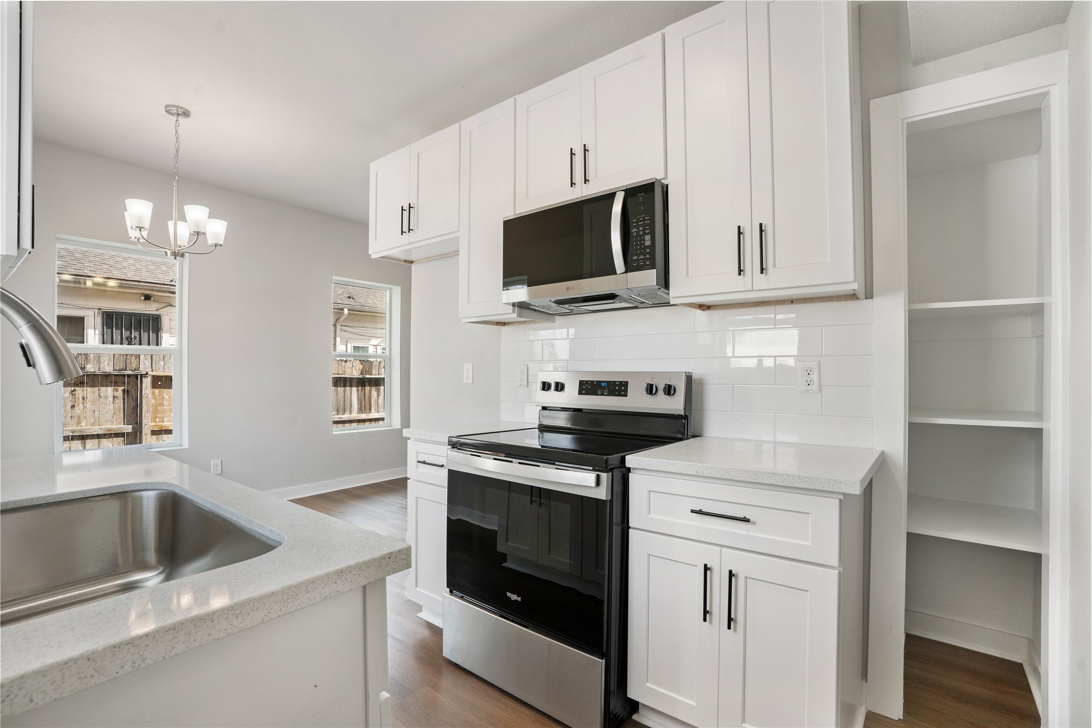 1115 Hogan Street, Unit 1 Houston, TX 77009 - Photo 11 of 12 a kitchen with white cabinets and stainless steel appliances