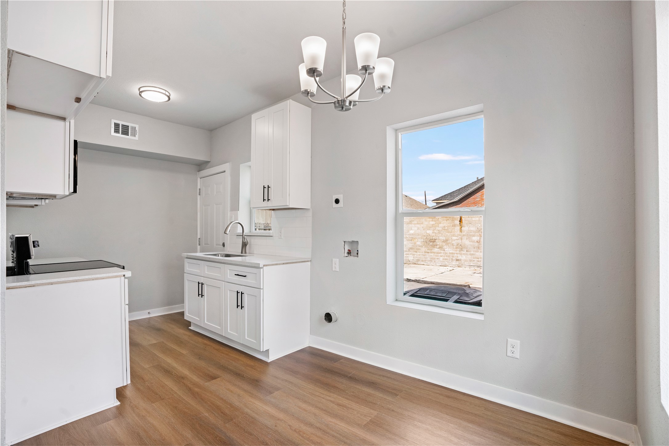 1115 Hogan Street, Unit 1 Houston, TX 77009 - Photo 7 of 12 a kitchen with stainless steel appliances granite countertop a stove a sink and a chandelier