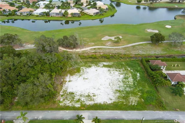 a view of a lake with a yard and large trees