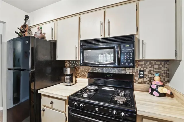 a kitchen with stainless steel appliances granite countertop a stove a refrigerator and a wooden cabinets