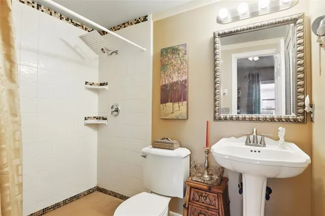 a bathroom with a sink a toilet and shower