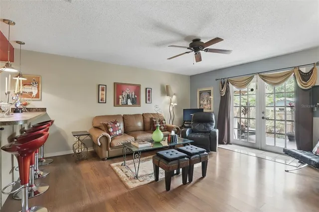 a living room with furniture large window and wooden floor