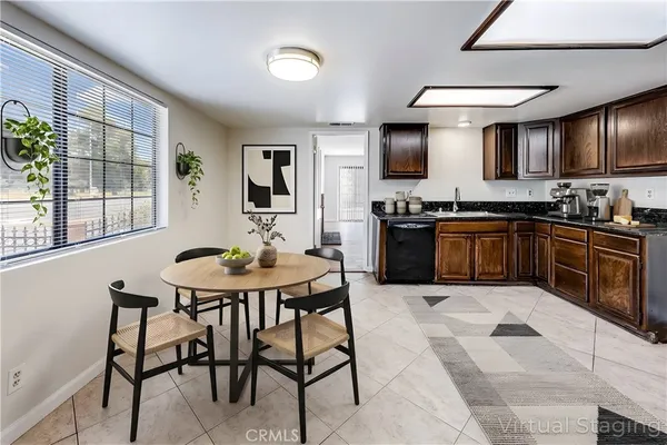 a kitchen with stainless steel appliances granite countertop a stove a sink dishwasher a dining table and chairs with wooden floor