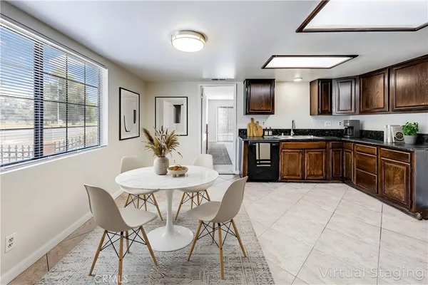 a kitchen with stainless steel appliances granite countertop a stove top oven a sink a dining table and chairs
