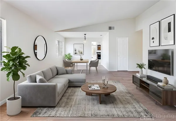 a living room with furniture a flat screen tv and a potted plant