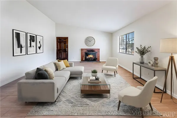 a living room with fireplace furniture and a wooden floor