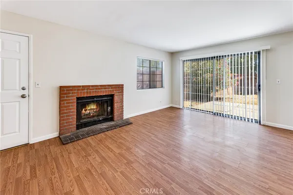 a view of empty room with wooden floor and fireplace
