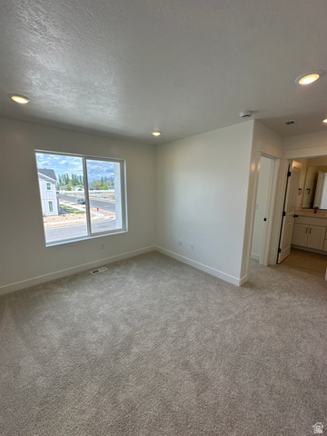 1225 West 500 South Logan, UT 84321 - Photo 27 of 39 Spacious room featuring neutral carpeting, white walls, recessed lighting, and a large window