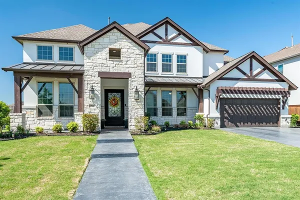 a front view of a house with yard and green space