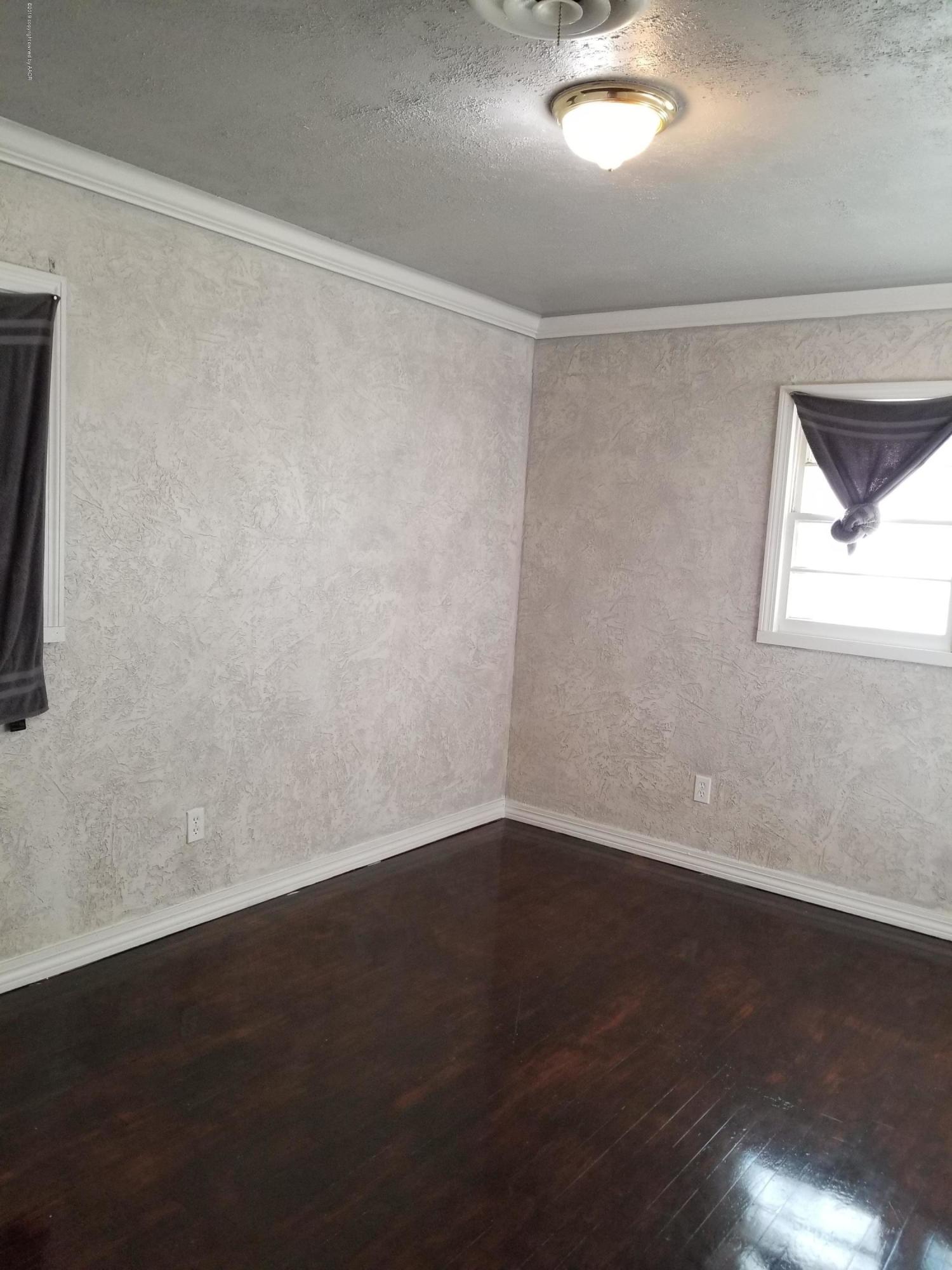 5104 South Bonham Street Amarillo, TX 79110 - Photo 8 of 10 an empty room with wooden floor and windows