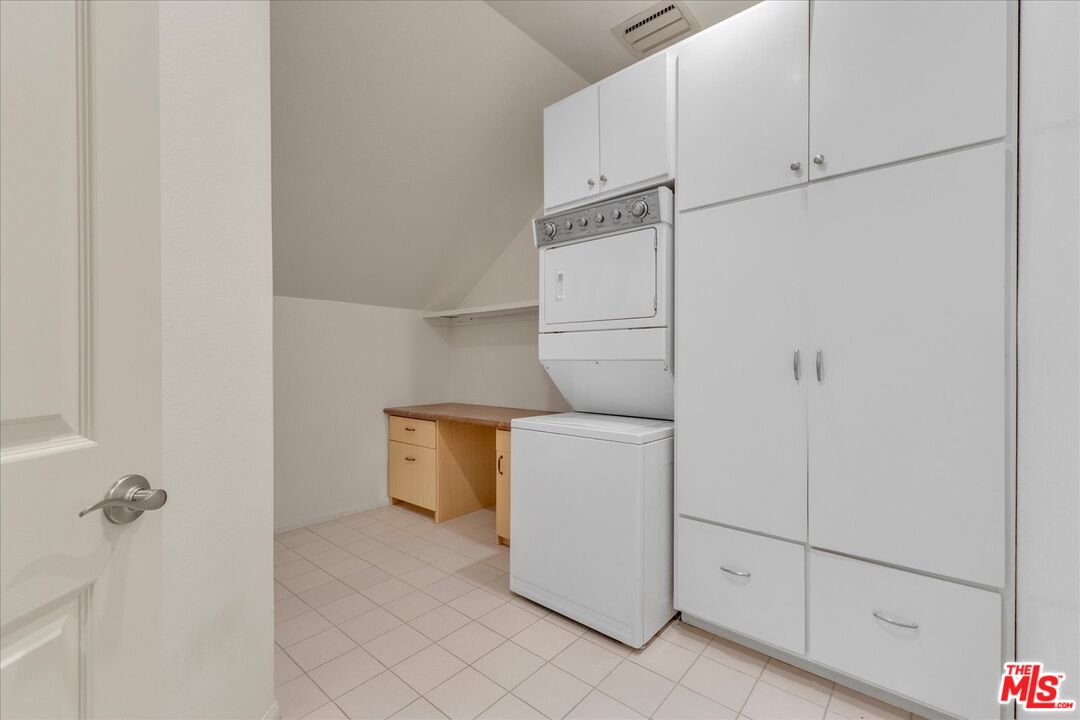 2202 The Terrace Los Angeles, CA 90049 - Photo 19 of 40 a utility room with cabinets washer and dryer