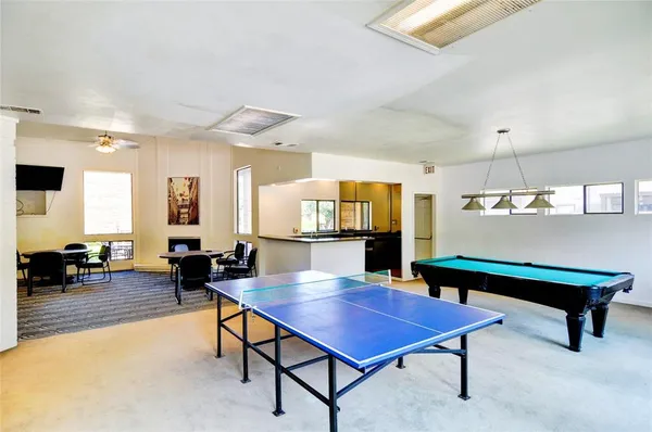 a living room with furniture a table and kitchen view