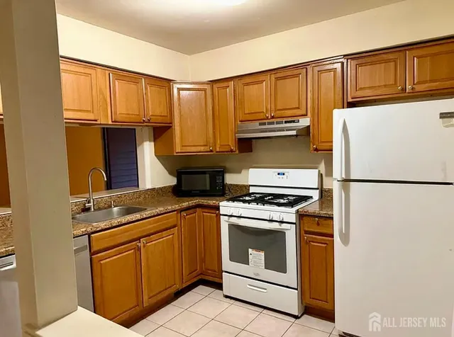 a kitchen with stainless steel appliances granite countertop a refrigerator stove and sink