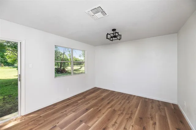 a view of a room with wooden floor and window