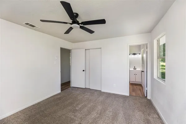 a view of a room with a ceiling fan and window