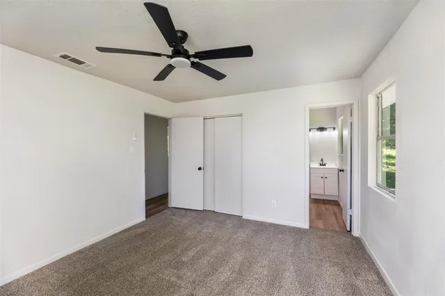 a view of a room with a ceiling fan and window