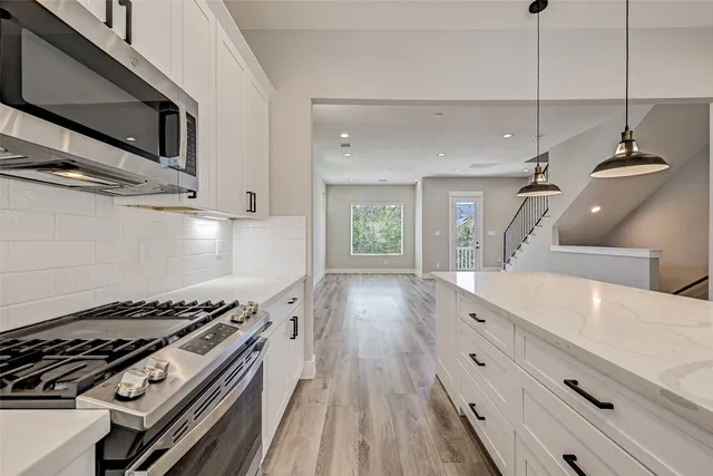 a kitchen with sink stove and cabinets