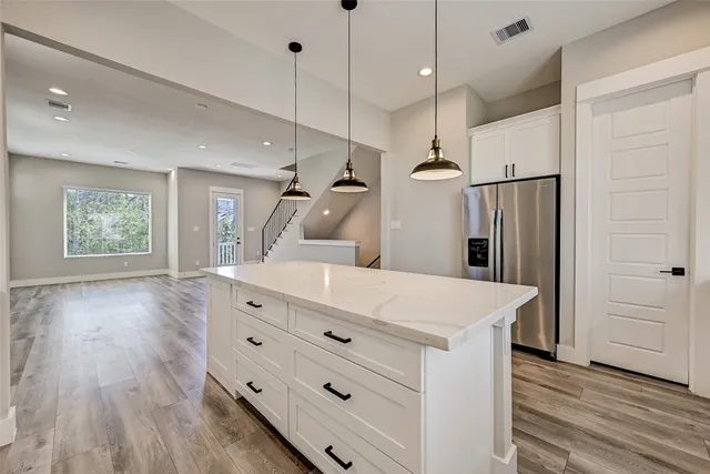 a kitchen with a refrigerator a sink and wooden floor