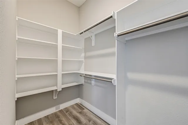 a view of walk in closet with empty racks