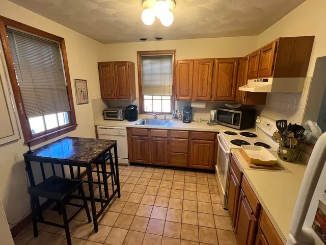 a kitchen with a sink a stove a refrigerator and cabinetry