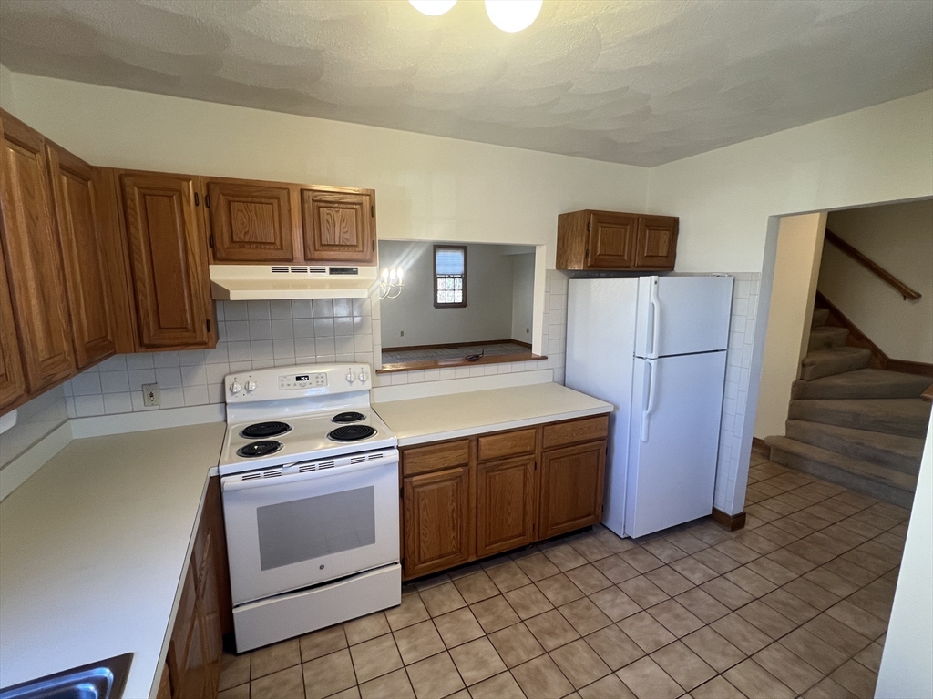 1050 Chestnut Street, Unit 1050 Newton, MA 02464 - Photo 5 of 13 a kitchen with a stove and a refrigerator