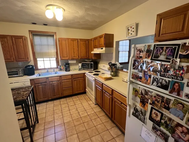 a kitchen with stainless steel appliances a stove a sink cabinets and a window
