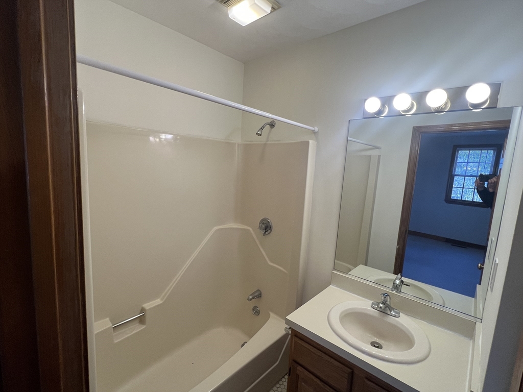 1050 Chestnut Street, Unit 1050 Newton, MA 02464 - Photo 8 of 13 a bathroom with a sink a mirror and a bathtub