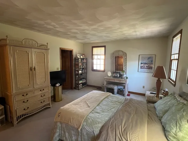 a bedroom with a bed a dresser and mirror