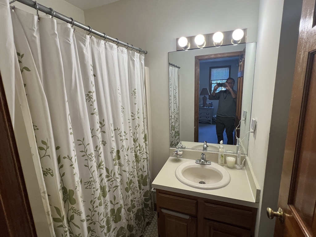 1050 Chestnut Street, Unit 1050 Newton, MA 02464 - Photo 9 of 15 a bathroom with a sink a mirror and a shower
