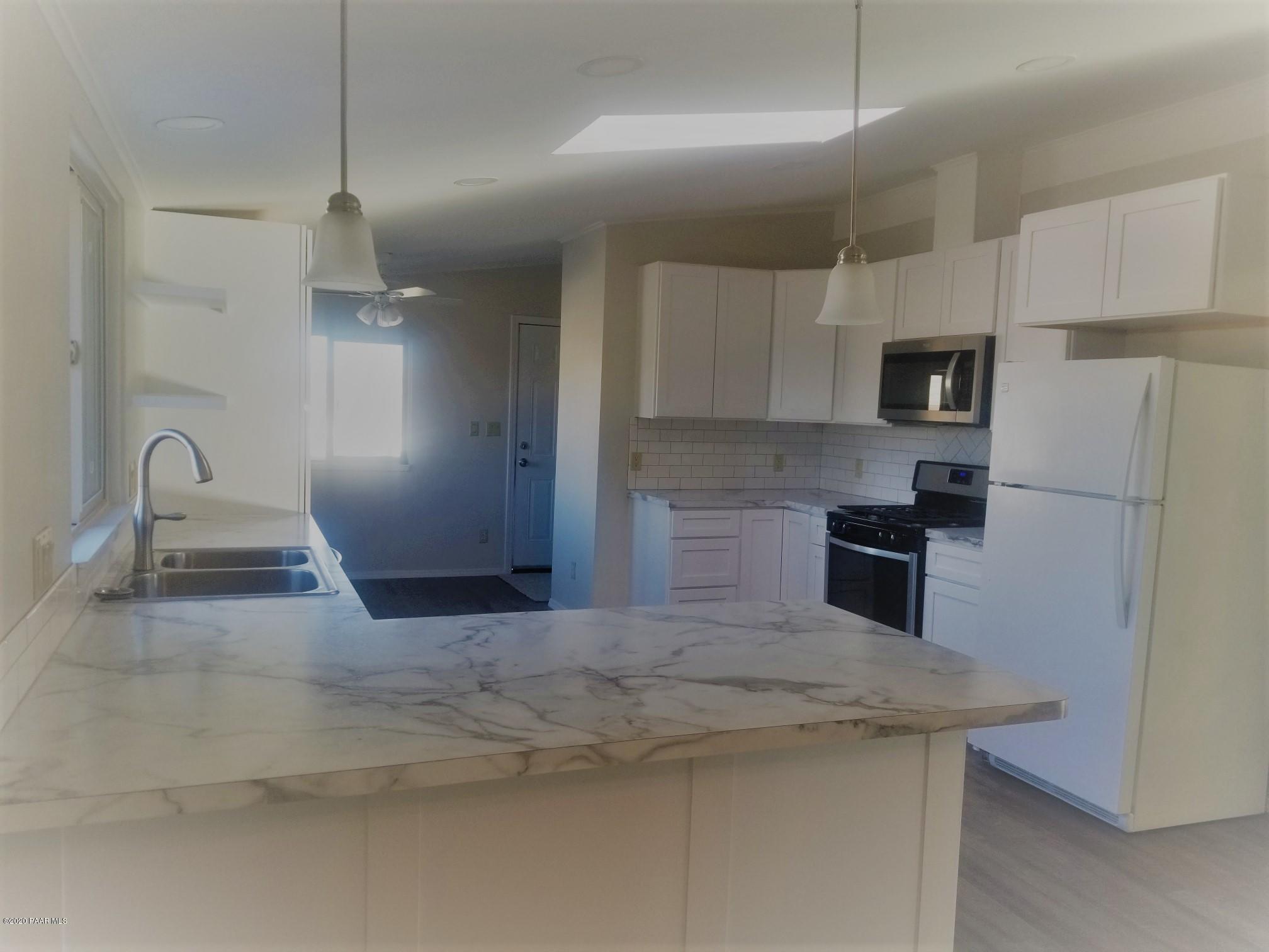 3361 North Reed Road Chino Valley, AZ 86323 - Photo 13 of 29 a kitchen with stainless steel appliances granite countertop a sink a stove and a refrigerator