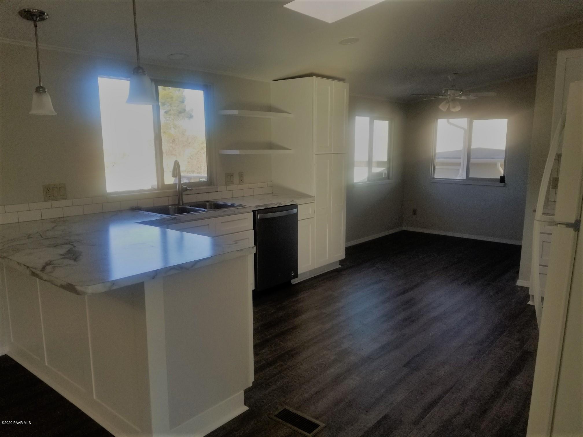 3361 North Reed Road Chino Valley, AZ 86323 - Photo 14 of 29 a kitchen with granite countertop a sink a window and wooden floor