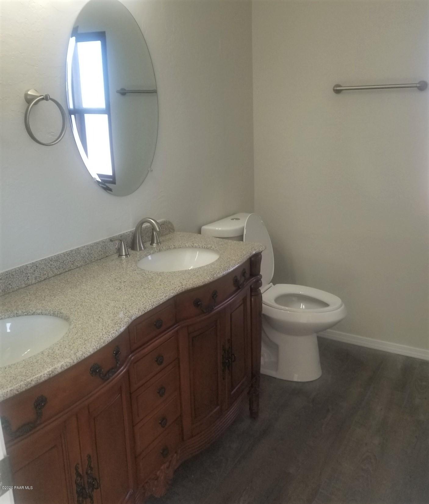 3361 North Reed Road Chino Valley, AZ 86323 - Photo 25 of 29 a bathroom with a granite countertop toilet sink and mirror