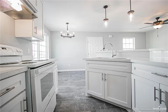 a kitchen with white cabinets and sink