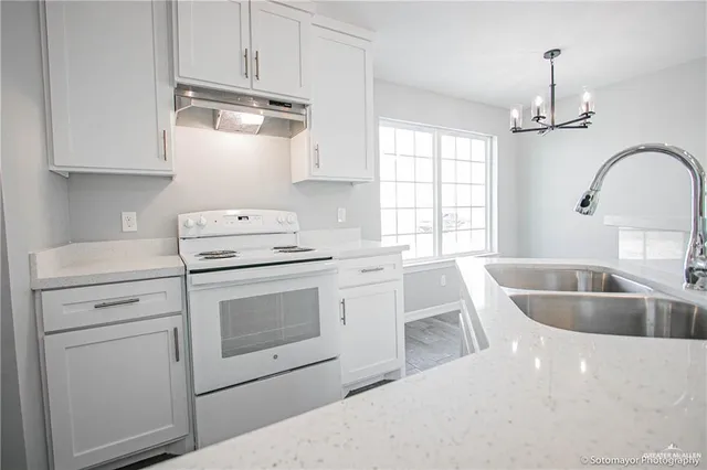 a kitchen with granite countertop a sink stainless steel appliances and cabinets