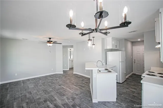 a view of a kitchen with a sink and chandelier