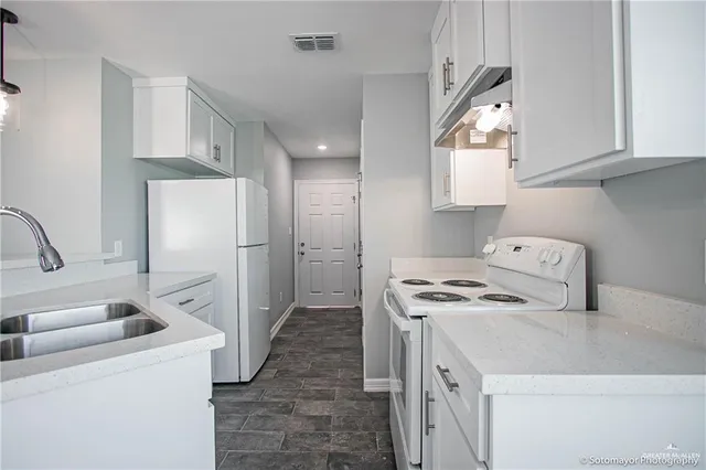 a kitchen with a stove a refrigerator and a sink