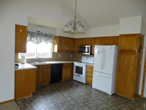 a kitchen with refrigerator cabinets and window