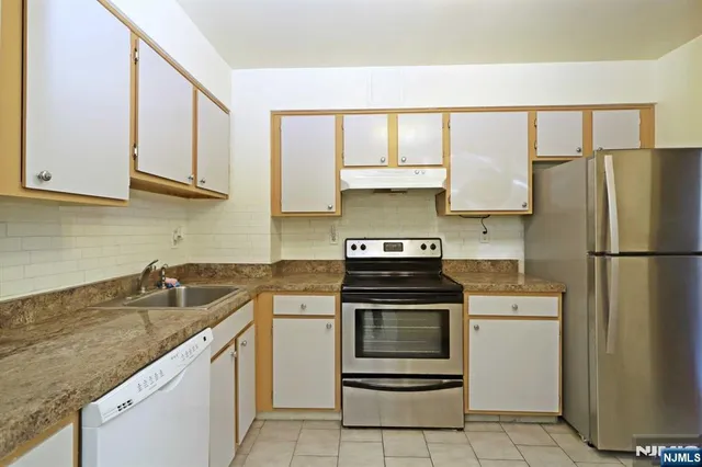 a kitchen with white cabinets and white appliances