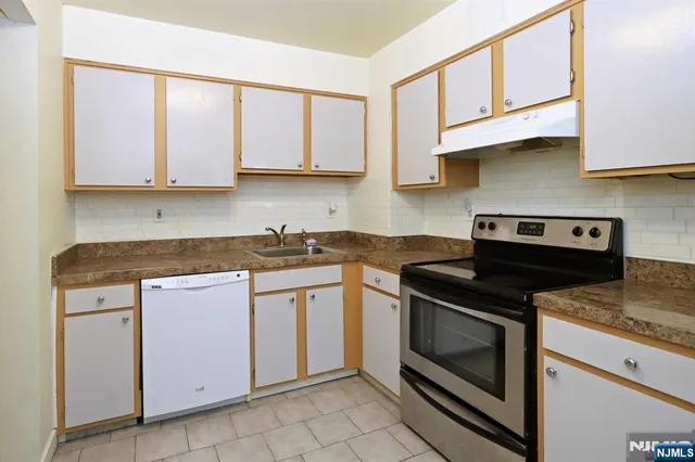 a kitchen with cabinets appliances and a sink