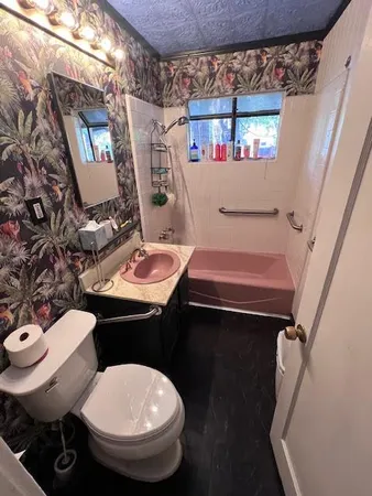 a bathroom with a sink toilet and a mirror