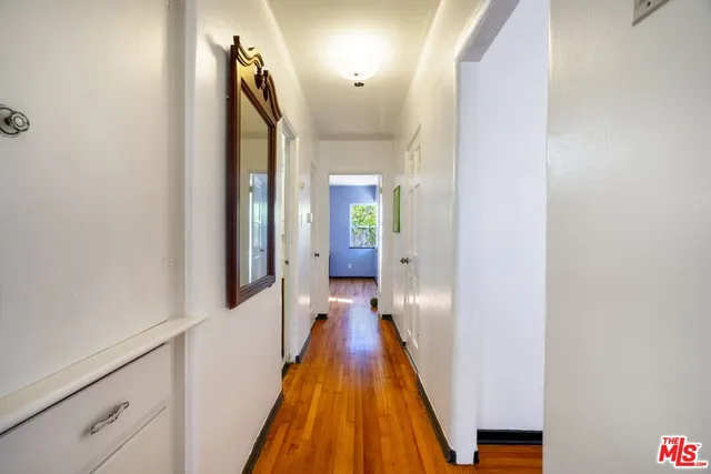 a view of a hallway with wooden floor and staircase